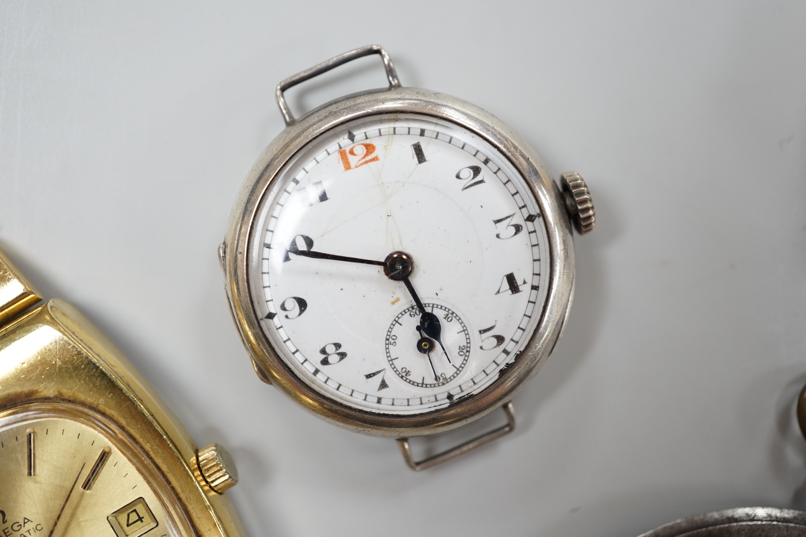 A George V silver pocket watch with arabic dial, 3.25cm, a gentleman's gold plated Omega Automatic wrist watch with loose bracelet, a gun metal dress watch and a Surena gold overlaid cocktail watch